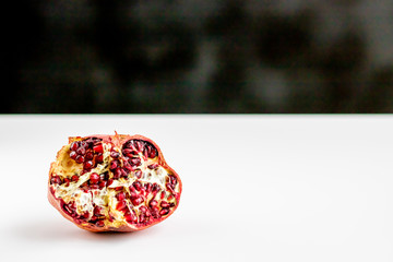 A piece of peeled ugly pomegrante on the table. Trendy concept of life withaut waste.