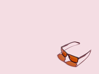 Sunglasses on a pink background. Minimalistic concept. Copy space.
