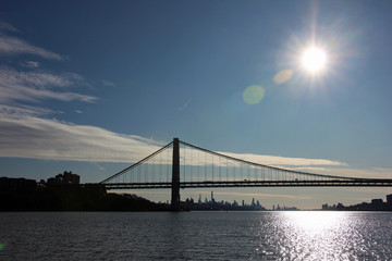 George Washington Bridge and Manhattan skyline in backlit view down the Hudson River