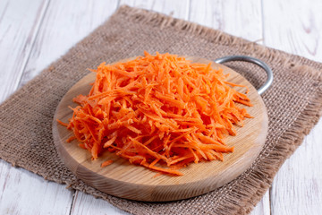Grated carrots on a cutting board on the table