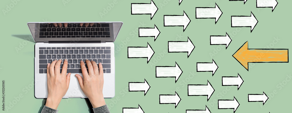Poster arrow going in the opposite direction with person using a laptop computer