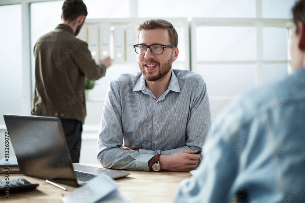 Wall mural close up. smiling businessman sitting at his desk