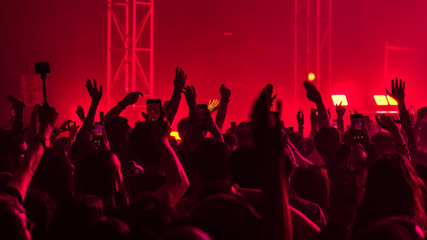 people having fun and dancing with their hands to the sky during a live music concert