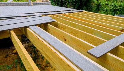 A new wooden, timber deck being constructed. it is on the decking.