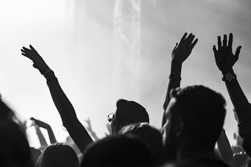  people having fun and dancing with their hands to the sky during a live music concert