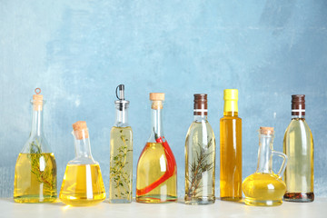 Different sorts of cooking oil in bottles on light grey table