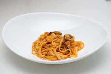 italian spaghetti with fish in white plate on white background