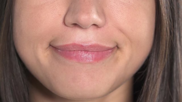 Close-up of a female lips. Woman is making funny facial grimace and smiling with perfectly white teeth