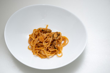 italian spaghetti with fish in white plate on white background