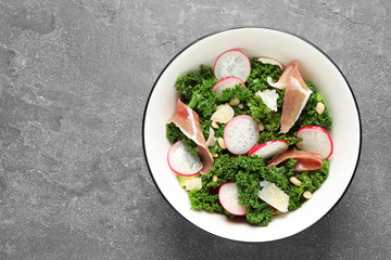 Tasty fresh kale salad on grey table, top view. Space for text