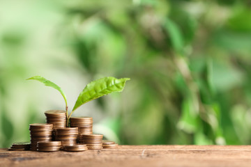 Money and sprout on wooden table against green blurred background, space for text