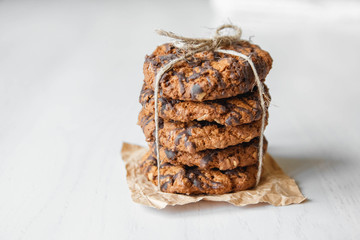 Delicious oatmeal cookies with chocolate on white table background. Copy, empty space for text