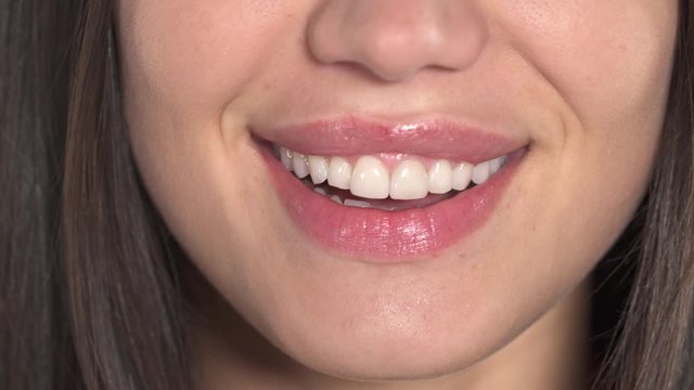 Close-up of a beautiful female lips. Woman is smiling with perfectly white teeth
