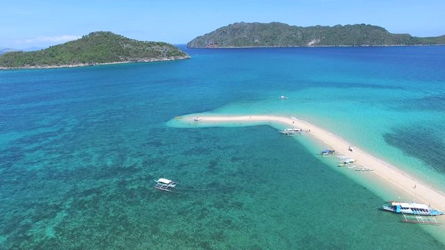 boats of tourist day trippers docked on an elbow skinny temporary sandbank formed by ocean currents moving sand and silt