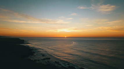 Obraz premium Landscape and sunset on the coast contemplating the breaking of the waves on the cliffs