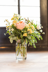 bouquet of flowers in a glass vase on wooden table