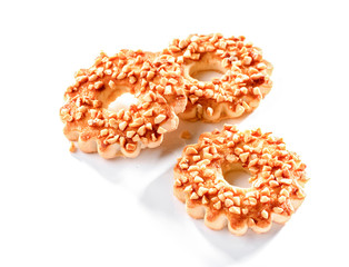 three cookies rings with chopped roasted peanuts close-up isolated on white background 