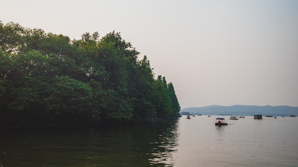 West Lake landscape with reflections in water at sunset, Hangzhou, China