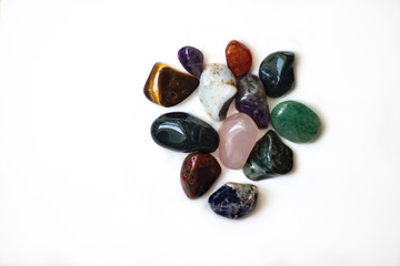 Multi-colored polished stones and minerals. Treated minerals and stones. Isolated minerals and stones: violet, green, beige, pink, orange, blue, beige.