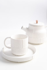 White mugs with a saucer and teapot. Kettle and Cups for coffee and tea on a white background. Utensils for any holiday, luxury wedding, birthday or party.