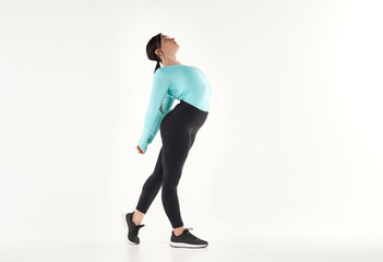 Obraz premium Young athletic woman making yoga and gymnastics stretching exercises isolated on white 