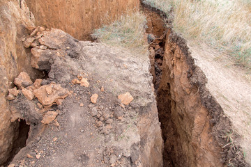 ecological disaster landslide of clay soil after an earthquake, a close up of earth cracks.