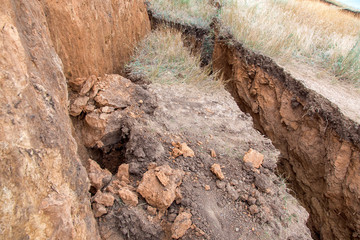 ecological disaster landslide of clay soil after an earthquake, a close up of earth cracks.