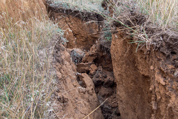 Fototapeta premium ecological disaster landslide of clay soil after an earthquake, a close up of earth cracks.