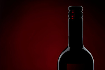Red Wine bottle silhouette isolated on black background, red backlight, horizontal with copy space
