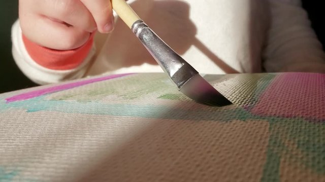 Child painting a picture up close 
