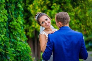 Obraz premium Bride and Groom at wedding Day walking Outdoors on spring nature. Bridal couple, Happy Newlywed woman and man embracing in green park. Loving wedding couple outdoor.