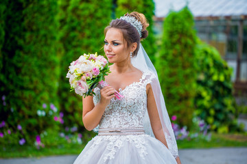 Bride holding bouquet of pink peonies. Close shot