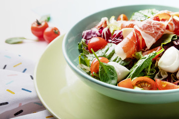 Salad with mozzarella mini, cherry tomatoes, spinach and prosciutto