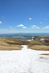 Magnificent panorama on top of a partially snowy volcanic mountain, during spring