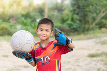 A child is playing football  together his friend.