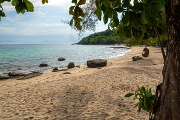 Seascape from the beach with swing seat under the tree; relaxation on the vacation trip