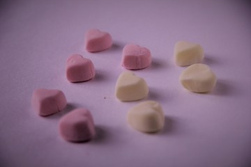Fototapeta na wymiar marshmallow pink and yellow in the form of a heart lies on the surface