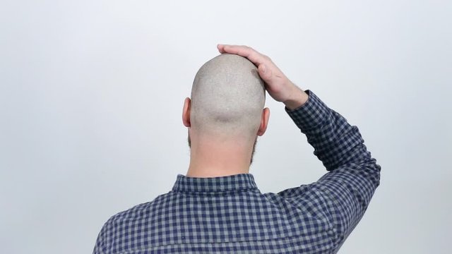 The guy sitting with his back to the camera and shows his bald head.