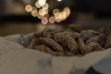 German and Austrian traditional Christmas cookies vanilla crescents on decorated plate powdered with castor sugar with Christmas lights.