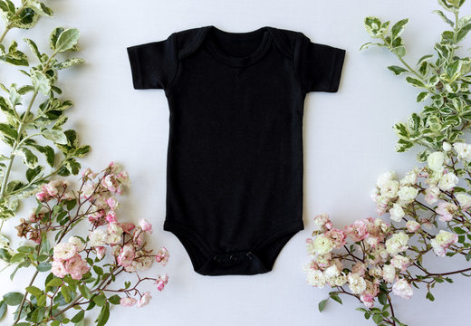 Blank Black Baby Grow On An Off White Background With Green Leaves and Pink Roses - Spring Baby Bodysuit Mockup - Styled Stock Photography