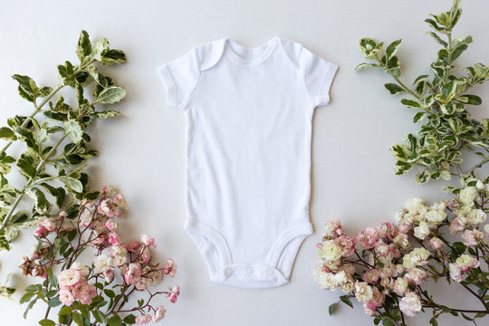 Blank White Baby Grow On An Off White Background With Green Leaves and Pink Roses - Spring Baby Bodysuit Mockup 