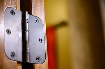 Oiled bronze door hinge on wood