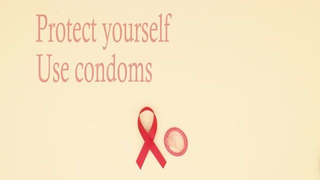 Stop AIDS. Protect yourself motivation quote appear with AIDS symbol and condoms on yellow background - Stop motion 
