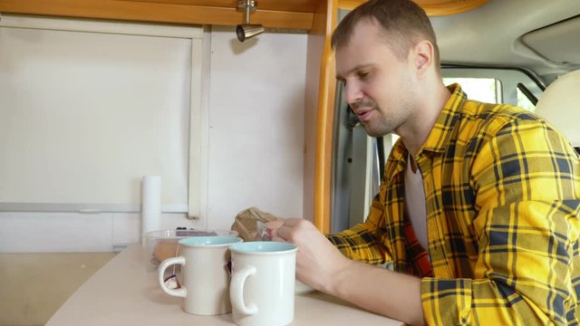 maman eating meat at a table in a motorhome. car travel concept