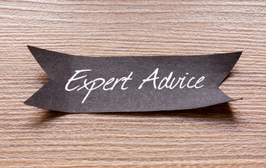 Expert Advice words written on Black papper with wooden background