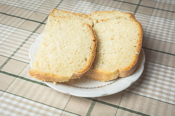 Sliced pieces of white bread in plate on kitchen table.