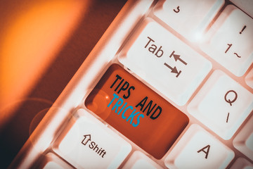 Obraz premium Conceptual hand writing showing Tips And Tricks. Concept meaning means piece advice maybe suggestion how improve White pc keyboard with note paper above the white background