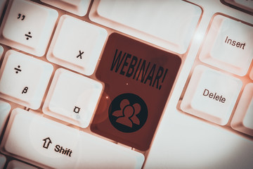 Writing note showing Webinar. Business concept for seminar or other presentation types that takes place on Internet White pc keyboard with note paper above the white background