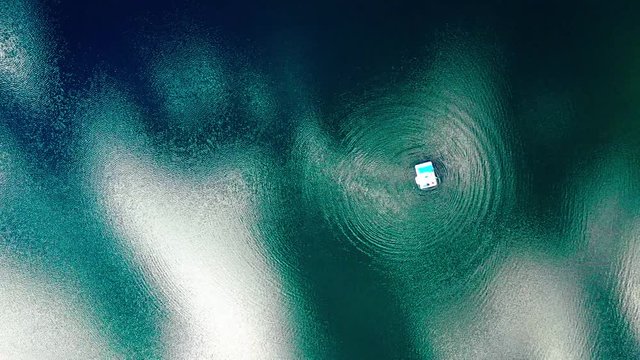 rubber boat on a lake making rings from high drone