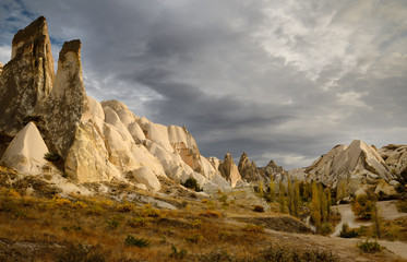 Fototapeta na wymiar Evening sun on rock spires of the Red Valley with hiking path south to Ortahisar Nevsehir Turkey